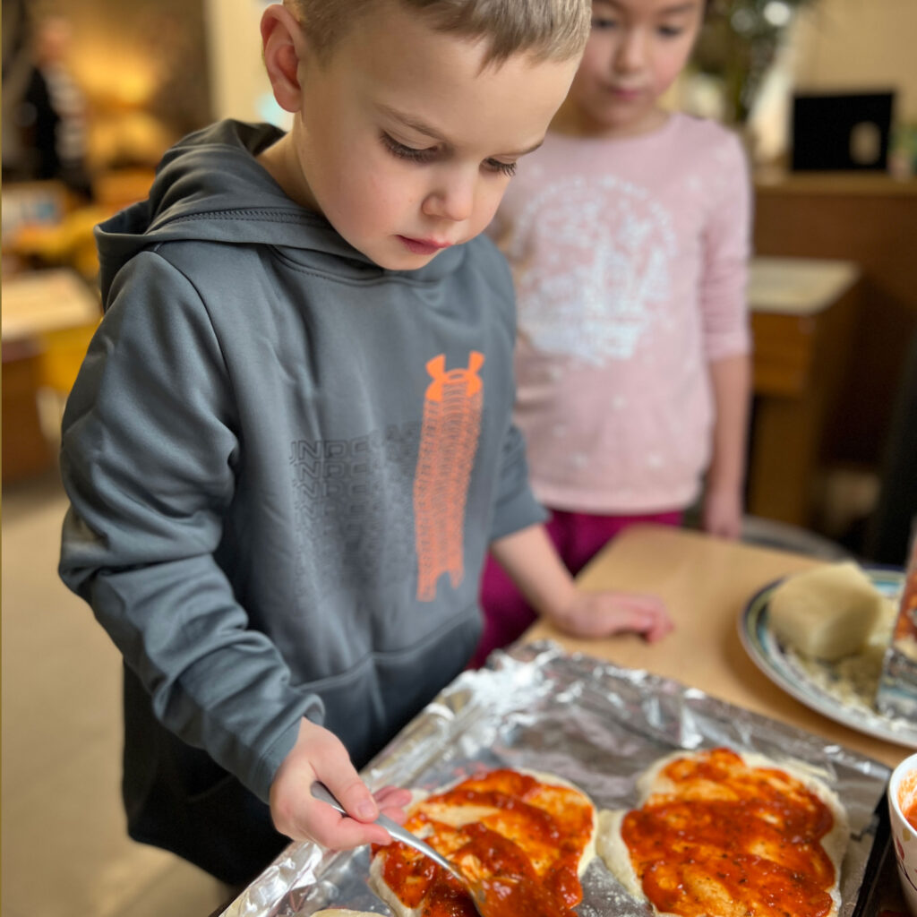 Kindergarten student making pizza for lunch